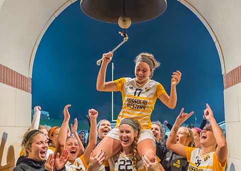 A soccer player rings the bell after a victory