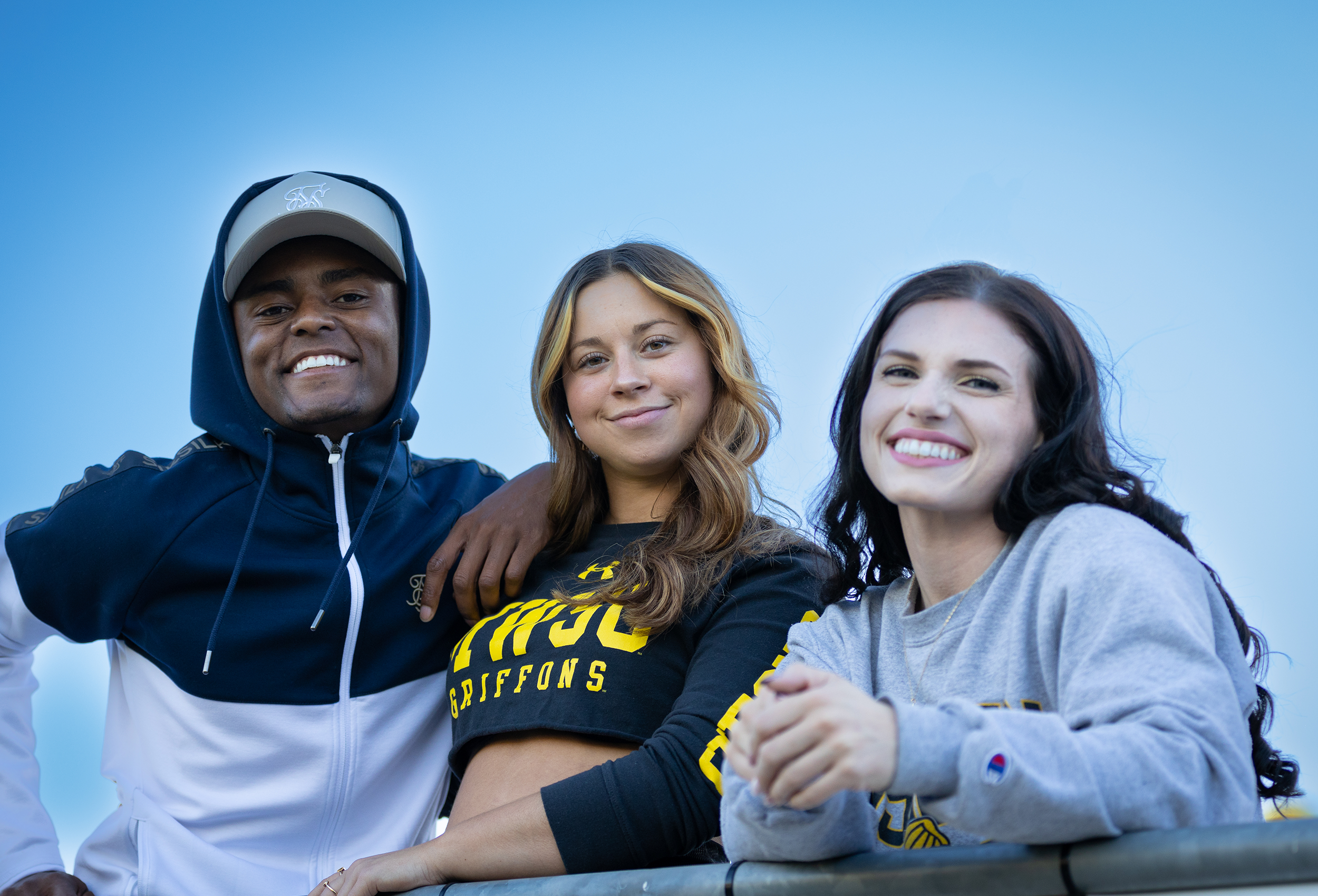three students posing and smiling for the camera