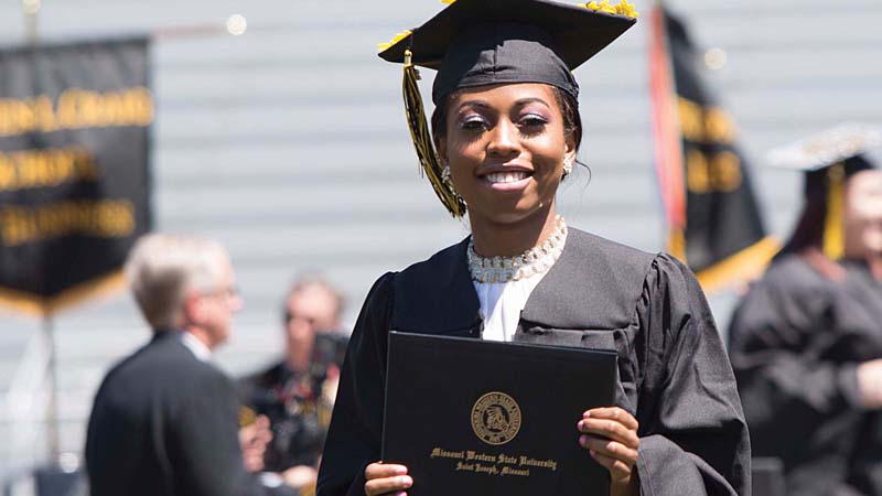 MWSU graduate holding degree at commencement ceremony