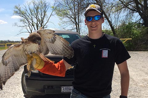 Student holding a wild bird