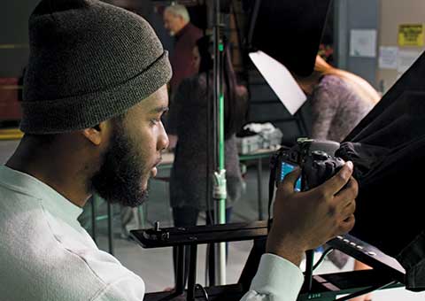 Two students film on campus using a high tech video camera