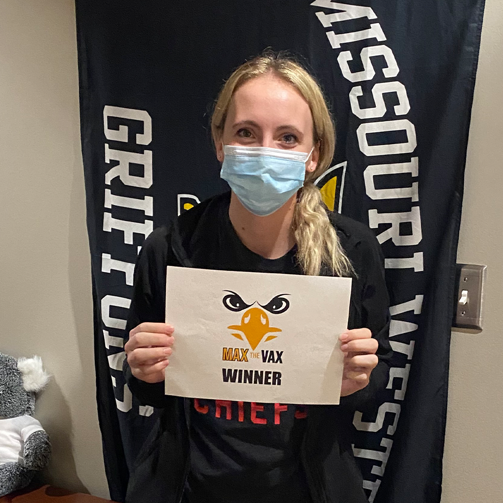 Kaitlyn Slagle holding her prize check with a missouri western banner in the background