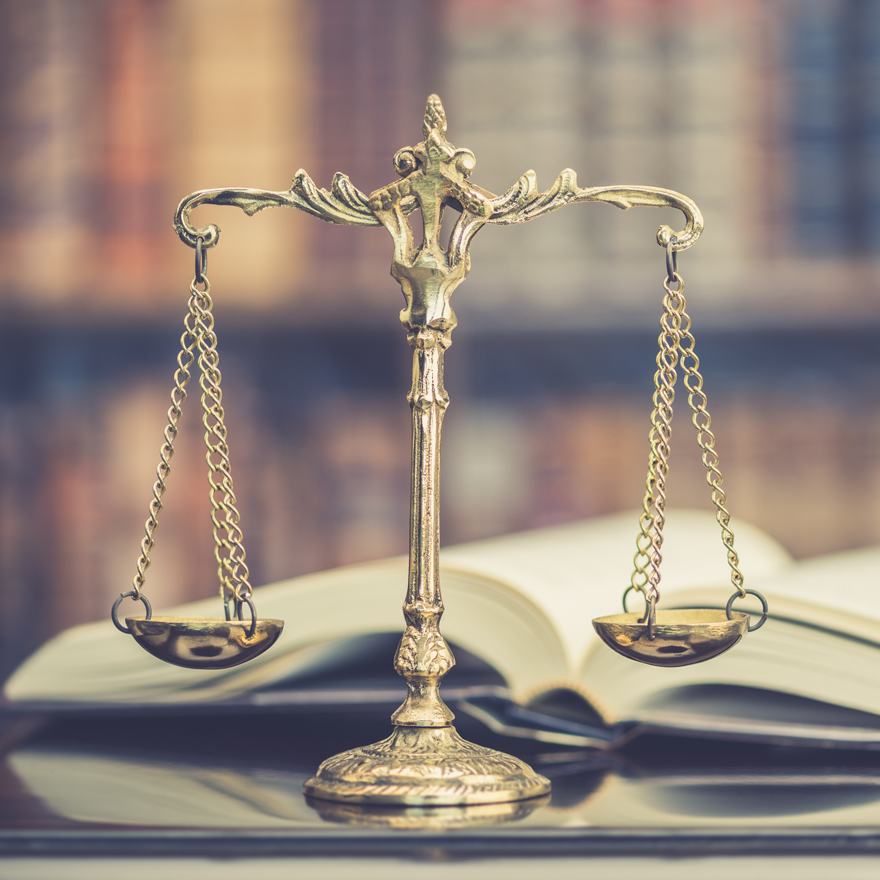 ParalegalCertificate2 Scales of justice sit on a table before a book