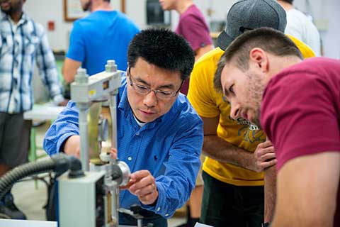 Instructor demonstrates how to use manufacturing equipment