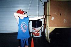 Child shooting an arrow during archery lesson