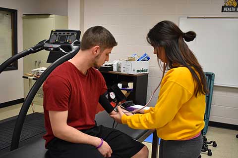Students practice taking each others blood pressure