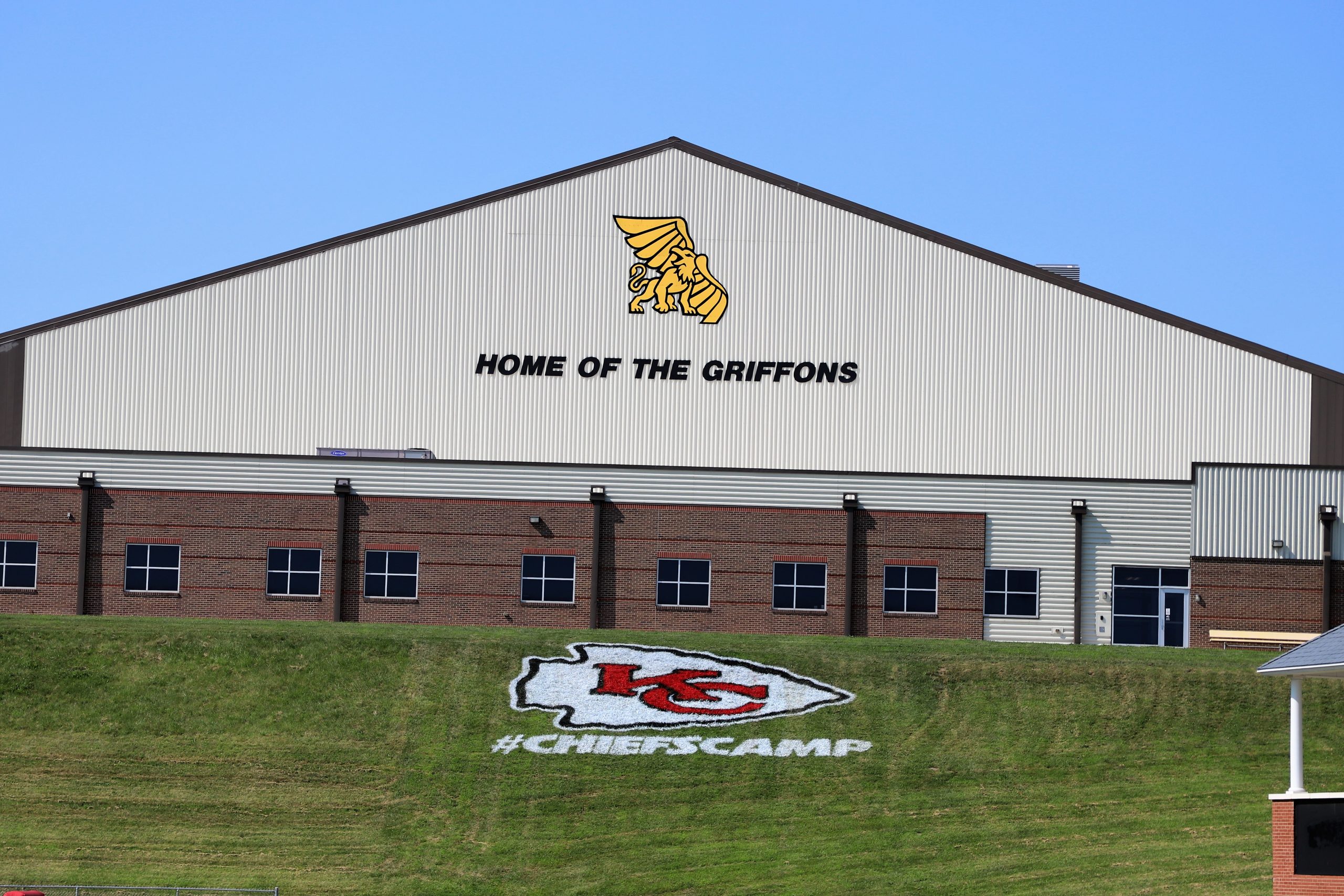 Home of the Griffons on side of building, Chiefs logo and #ChiefsCamp painted on hiillside in front of building