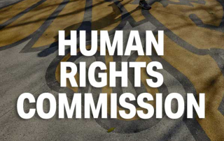 text that reads human rights commission with a griffon logo painted on the sidewalk in the background
