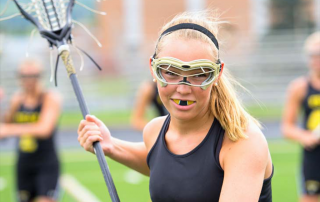 lacrosse player on lacross field with teammates in the background
