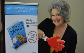 Candy Whirley giving a presentation with a red toy hand