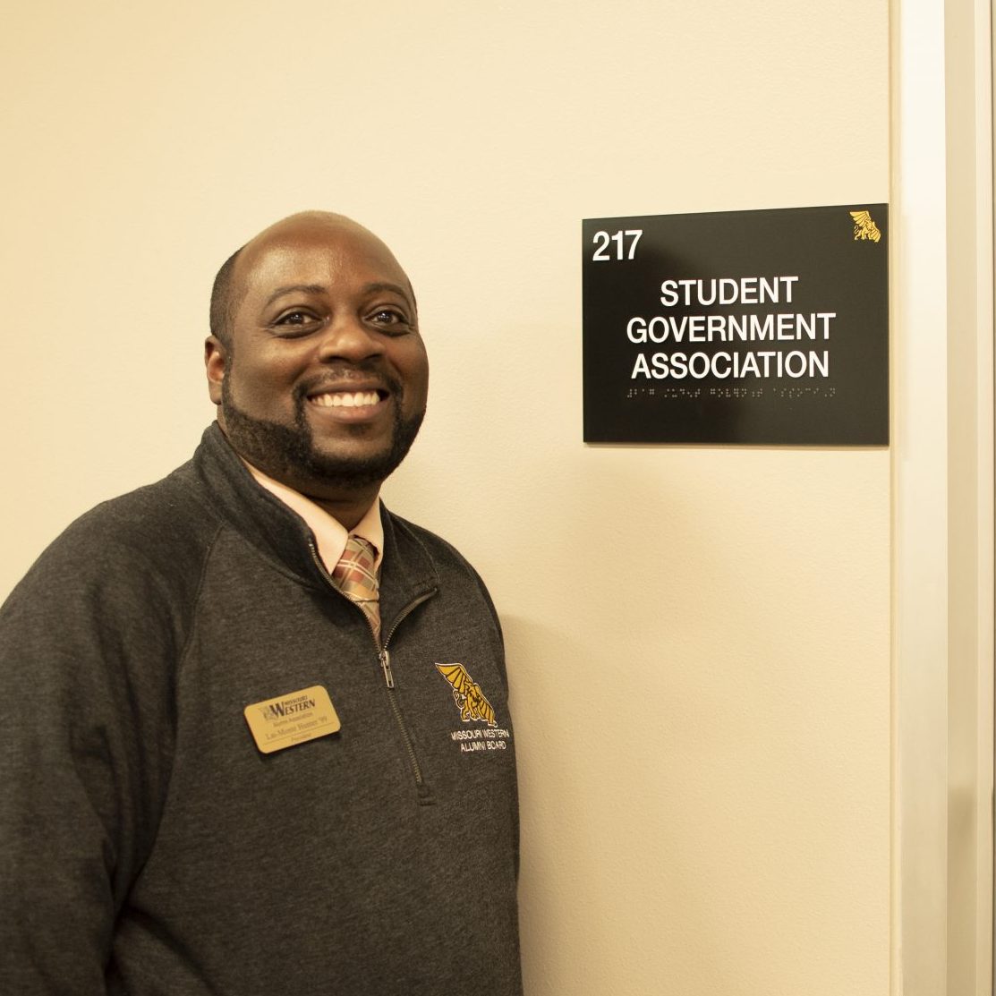 Lai-Monté Hunter posing next to the student government association office