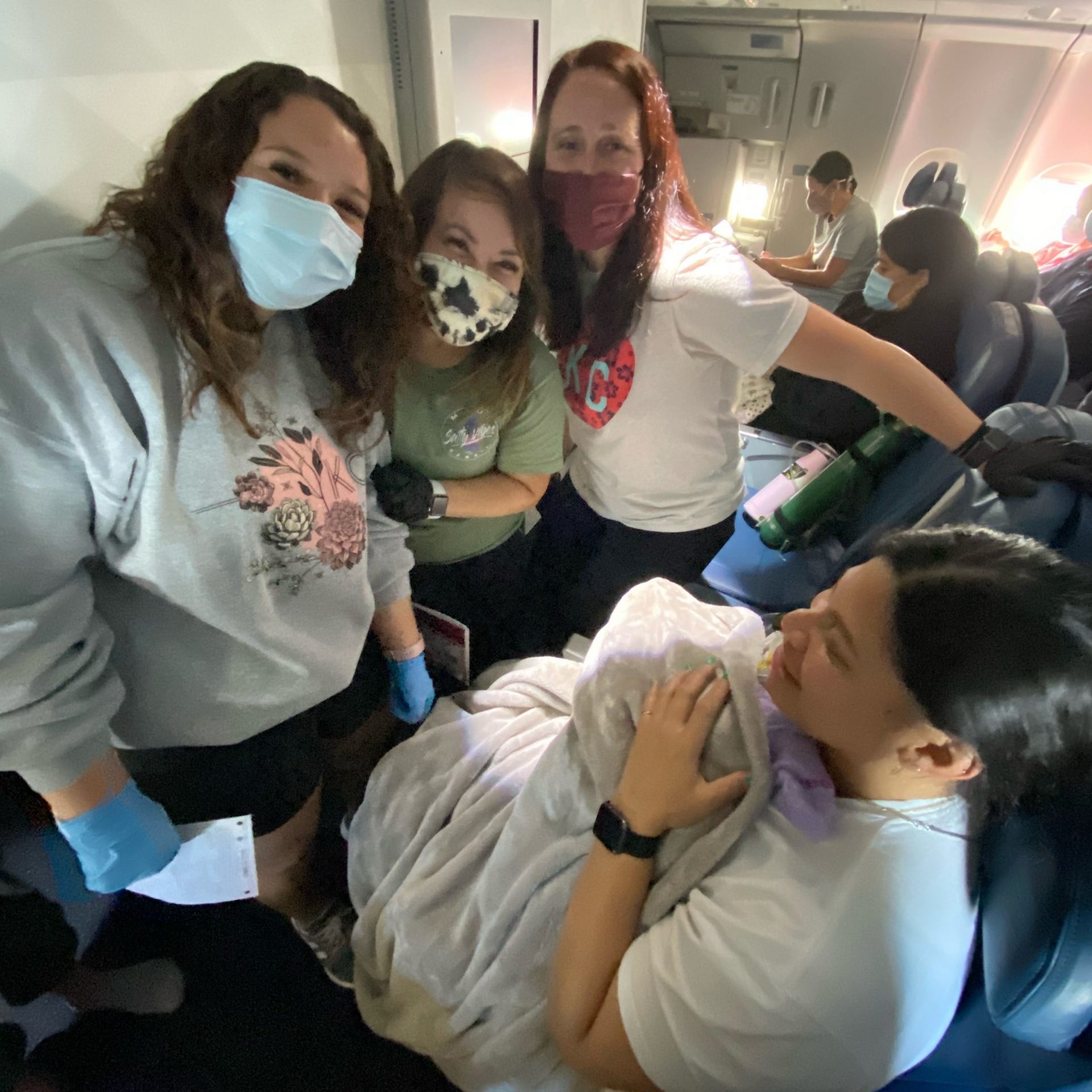 three nurses posing for a photo with mom and baby