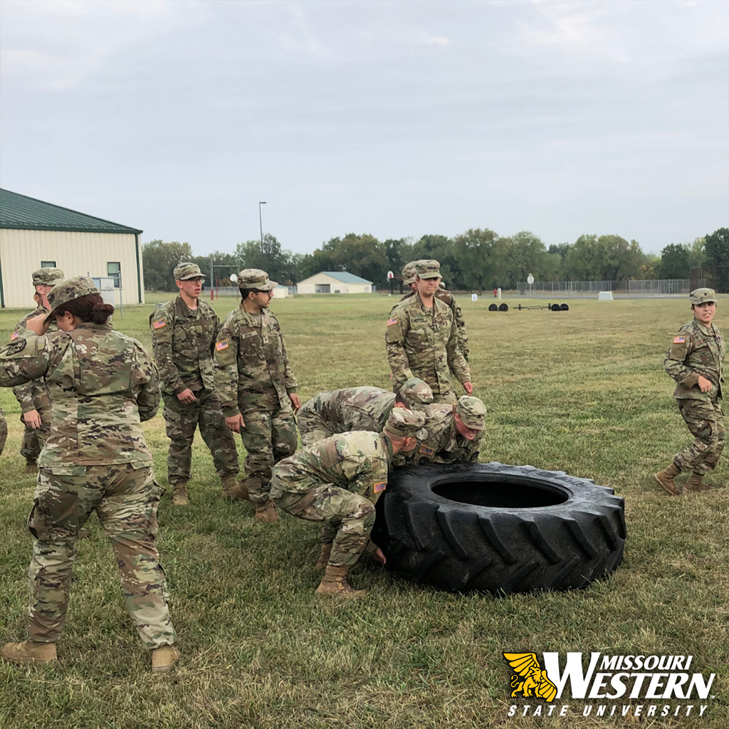 Soldiers pushing a tire