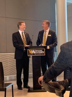 Matt Wilson and Dave Liechti stand smiling at a podium