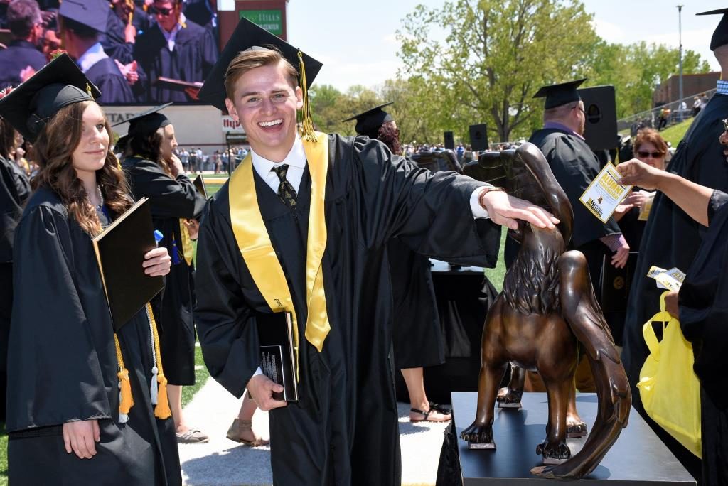 graduating MWSU student rubs the Griffon for good luck