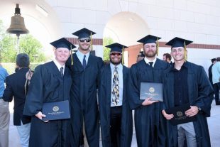 graduates smile after receiving diplomas