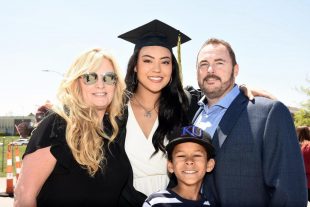 graduate poses with family