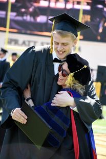 professor hugs a graduating student