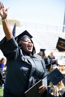 graduate celebrates after receiving her diploma