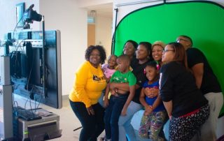 adults and children pose in a photo booth at Missouri Western's family weekend