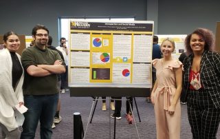 students pose with research poster