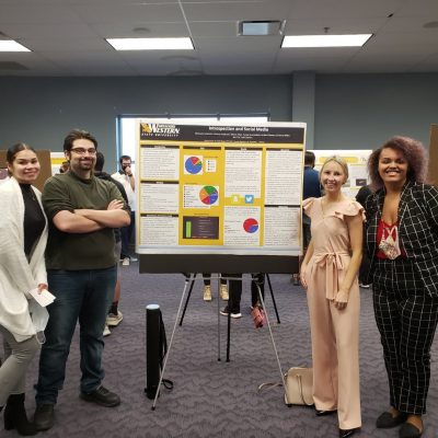 students pose with research poster