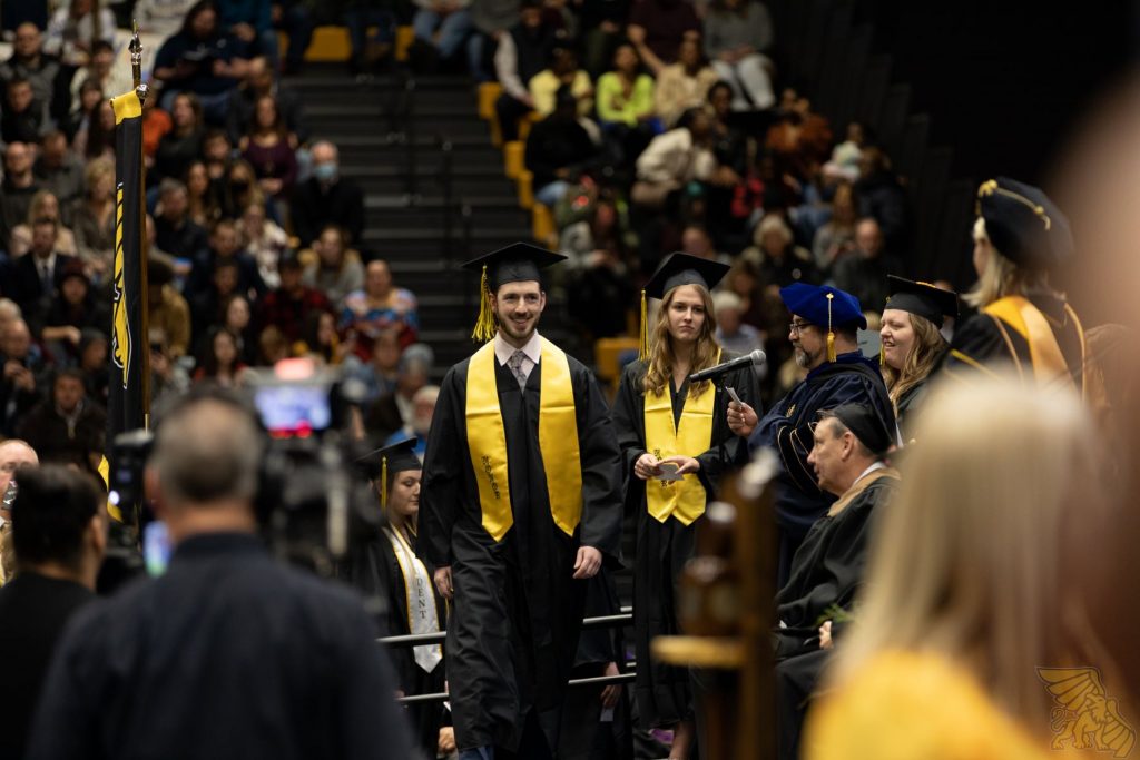graduate crosses stage