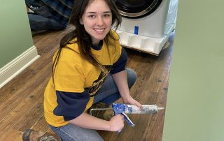 student volunteer with caulk gun