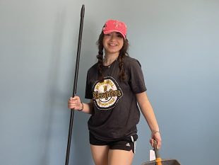 student volunteer with broom and dustpan