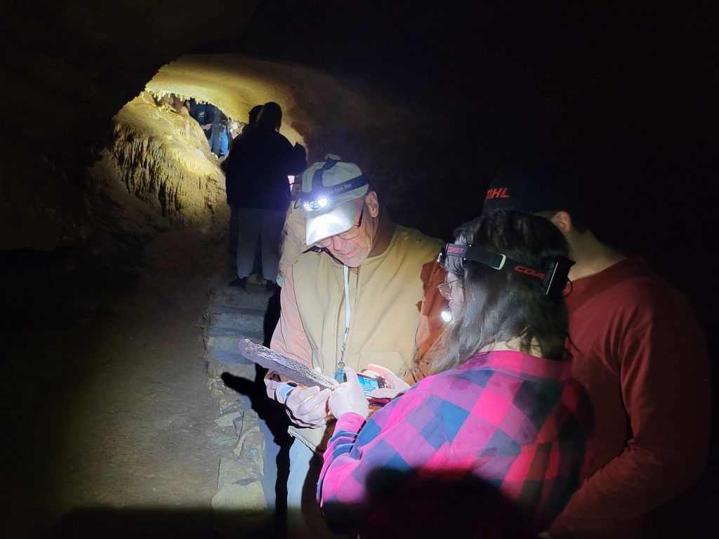biology students and professor in cave