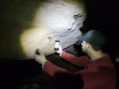 photographing a bat in a cave