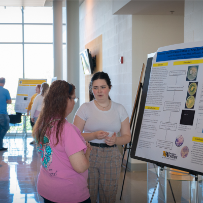 student explains research poster