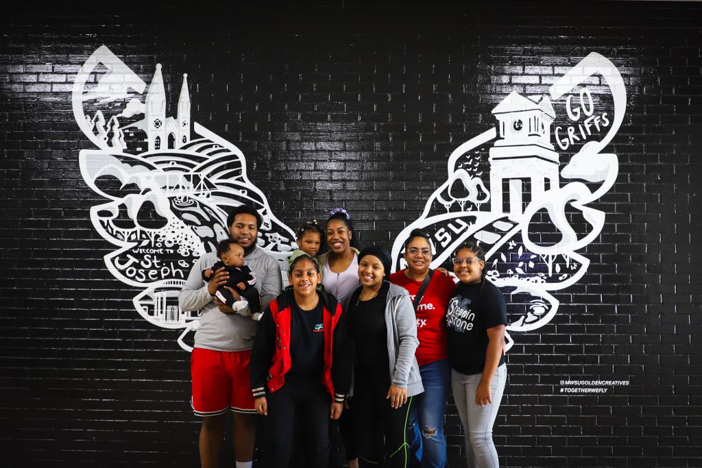 family in front of griffon wings