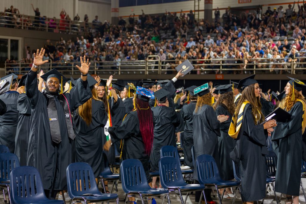 graduates wave to their families during Spring 2023 MWSU Commencement