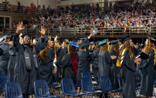 graduates wave to their families during Spring 2023 MWSU Commencement