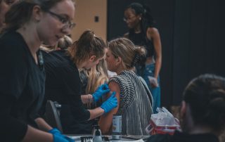 nursing student applies bandage after administering flu vaccine