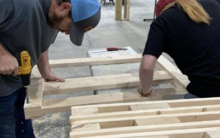 volunteers build a bed from lumber