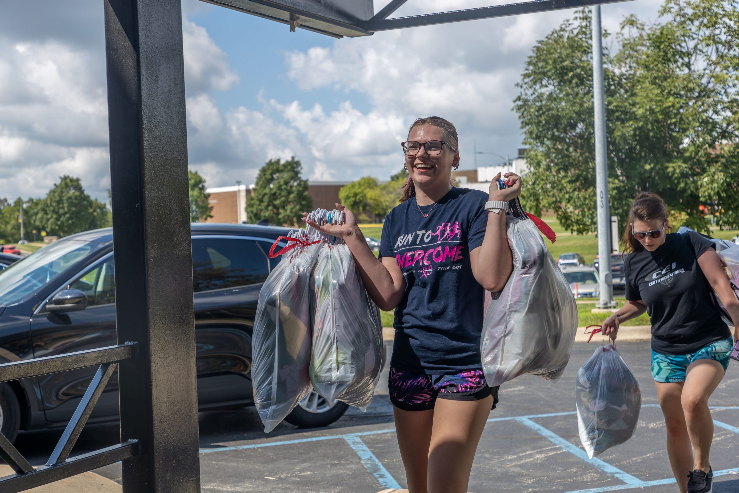student carries bags into residence hall