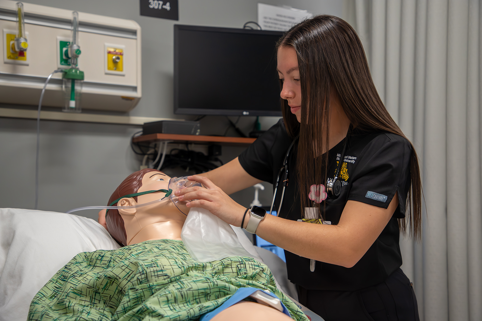 student nurse with patient mannequin