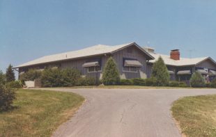 short driveway to gray ranch style home