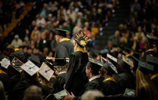 grad stands with "I did it" written on cap
