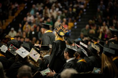 grad stands with "I did it" written on cap