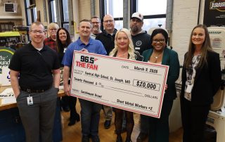 Jennifer Fitzpatrick accepts ceremonial check in her woodshop classroom.