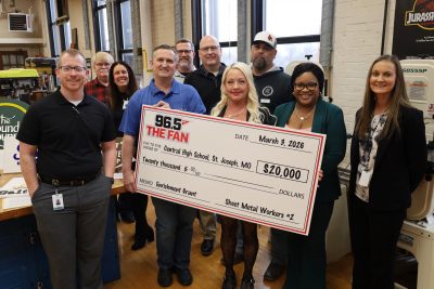 Jennifer Fitzpatrick accepts ceremonial check in her woodshop classroom.