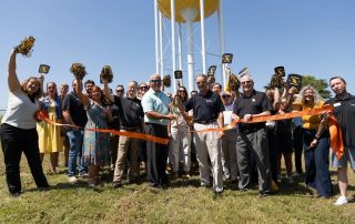 ribbon cutting in front of water tower