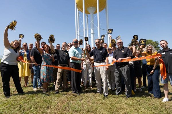 ribbon cutting in front of water tower