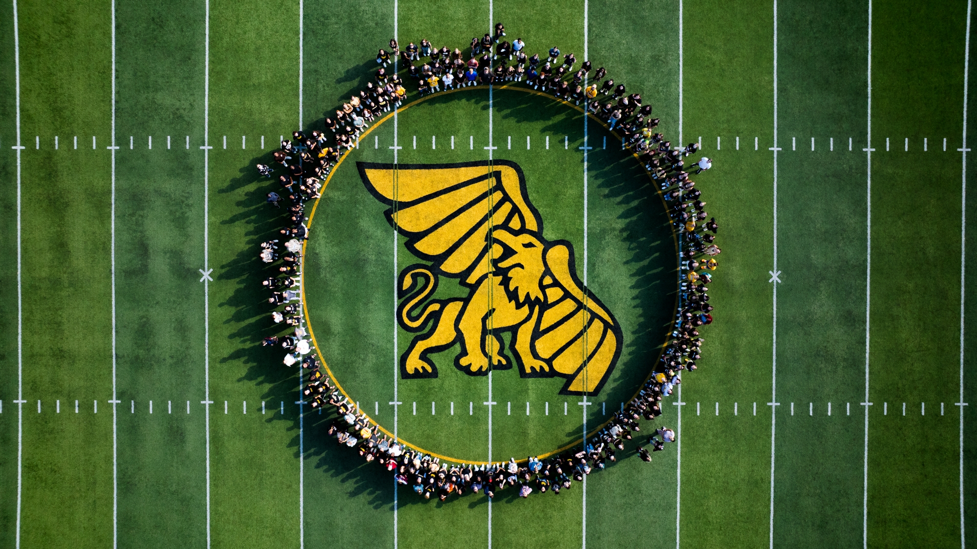 Griffon Edge students circle the Griffon on Spratt Stadium's field.