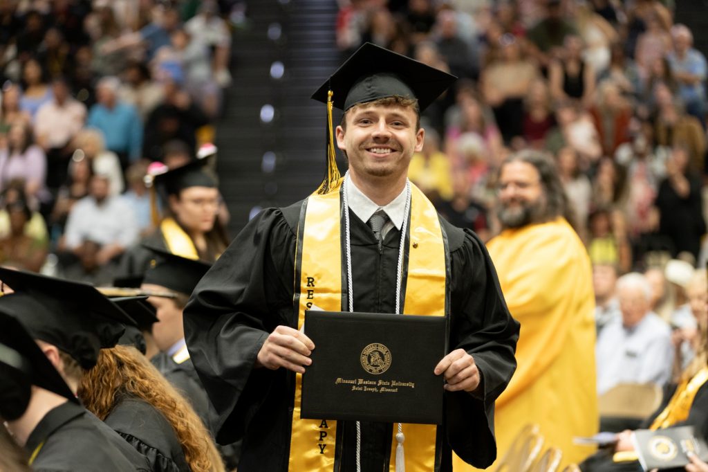 smiling graduate holds diploma