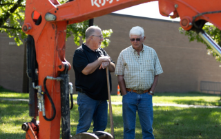 two men and an excavator