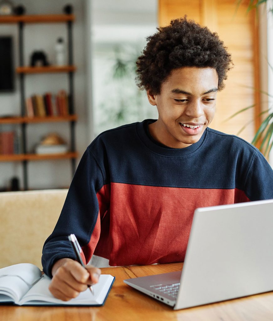 Student on laptop at table at home